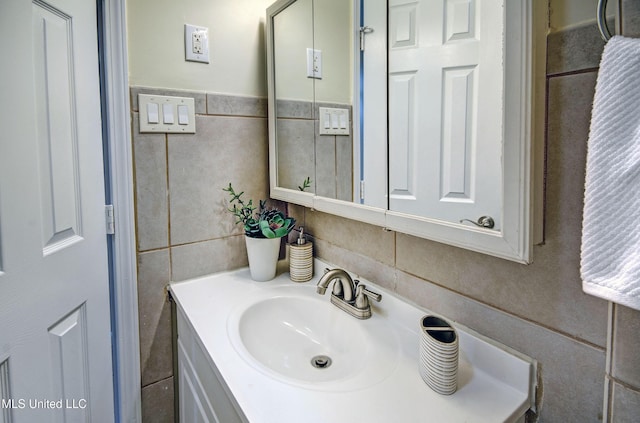 bathroom with vanity and tile walls