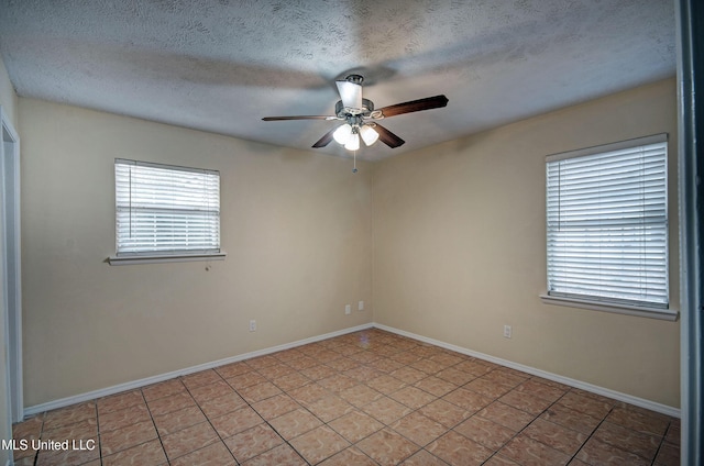 tiled empty room featuring ceiling fan and a textured ceiling