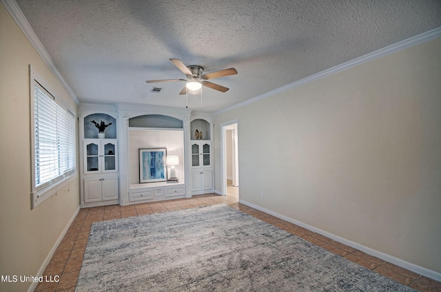 unfurnished living room featuring built in shelves, a textured ceiling, light tile patterned floors, ornamental molding, and ceiling fan