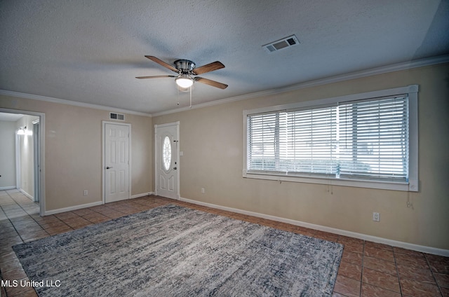 tiled entrance foyer with crown molding, ceiling fan, and a textured ceiling