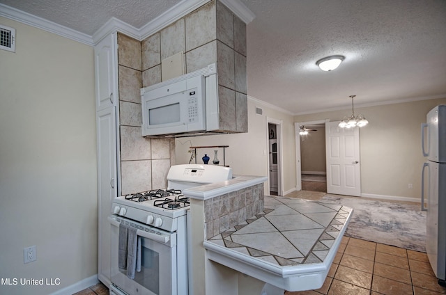 kitchen featuring crown molding, white appliances, tile counters, and tasteful backsplash