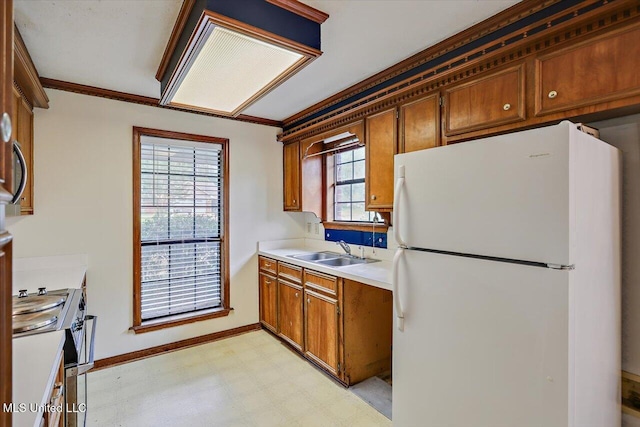 634 Twin Harbor Pl, Madison, MS 39110 - kitchen with freestanding refrigerator, a sink, light flooring, stainless steel range oven, and brown cabinets