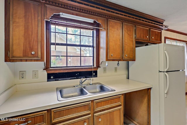 634 Twin Harbor Pl, Madison, MS 39110 - kitchen with a sink, freestanding refrigerator, light countertops, and brown cabinetry