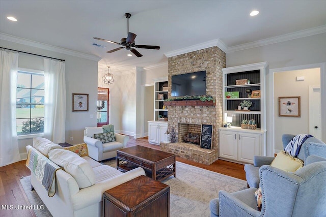 living room featuring ceiling fan, ornamental molding, light hardwood / wood-style floors, and a brick fireplace