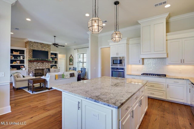 kitchen with pendant lighting, white cabinetry, a kitchen island, and appliances with stainless steel finishes