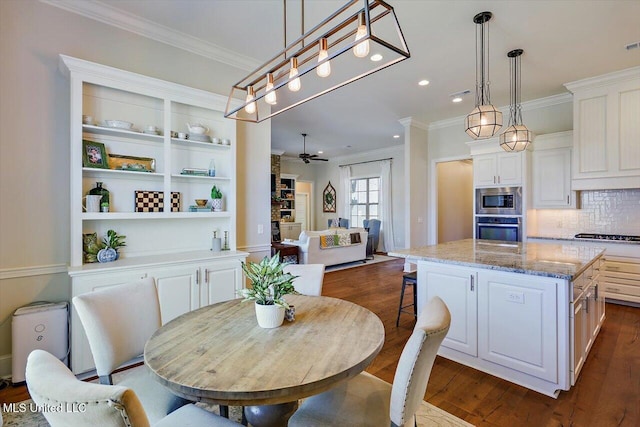 dining space featuring dark wood-type flooring, ceiling fan, and ornamental molding