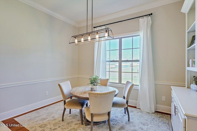 dining area with crown molding, a chandelier, and light wood-type flooring