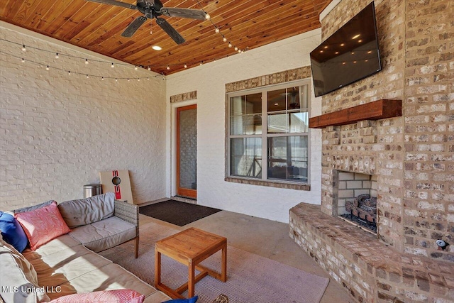 view of patio with an outdoor living space with a fireplace and ceiling fan