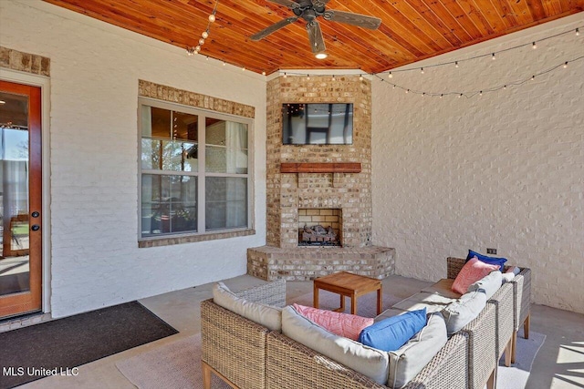 view of patio / terrace with ceiling fan and an outdoor living space with a fireplace