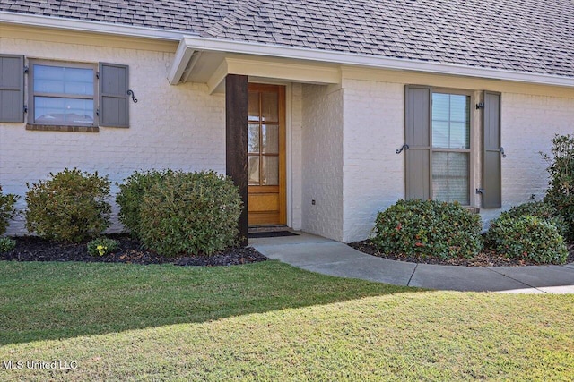 view of exterior entry featuring a yard