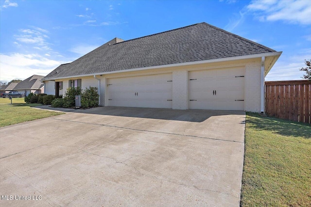 view of side of home featuring a garage and a yard