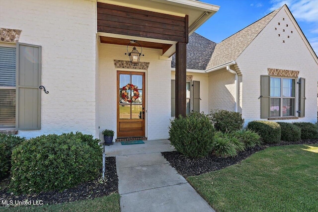 view of exterior entry with a yard