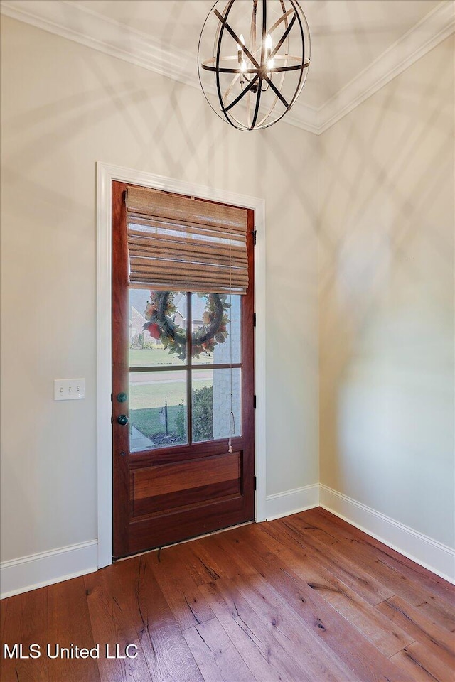 entryway with crown molding, a chandelier, and hardwood / wood-style flooring