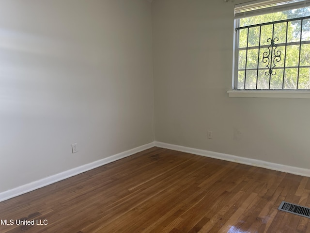 unfurnished room featuring baseboards and wood finished floors