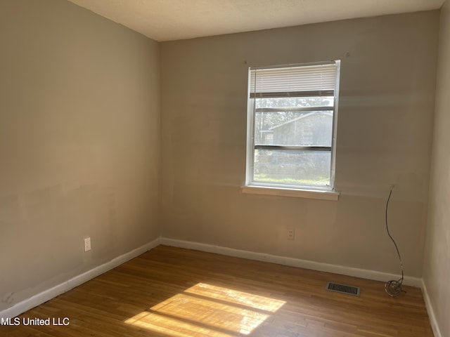 spare room featuring wood finished floors and baseboards