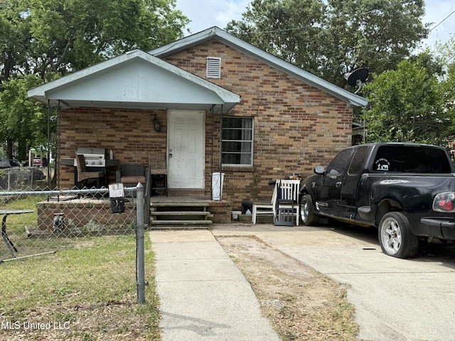 view of front of home with brick siding and fence