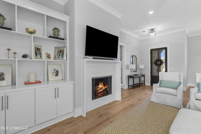 living room with built in shelves, light hardwood / wood-style floors, and ornamental molding