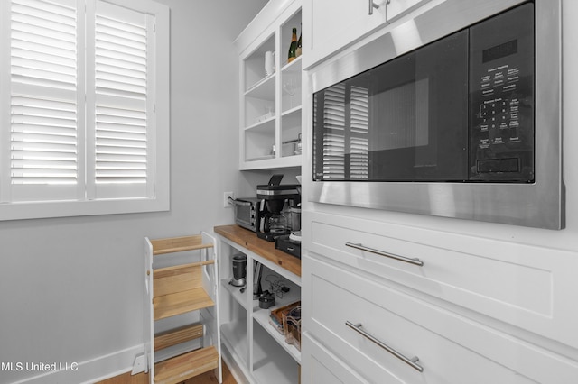 interior space with white cabinetry and built in microwave