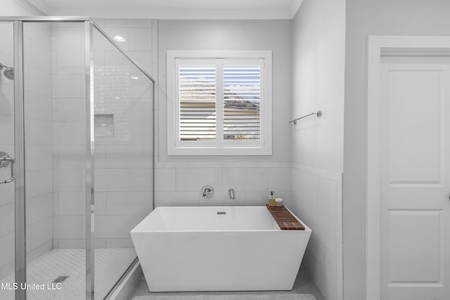 bathroom featuring tile walls and independent shower and bath