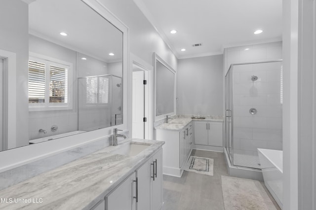 bathroom featuring vanity, independent shower and bath, and ornamental molding