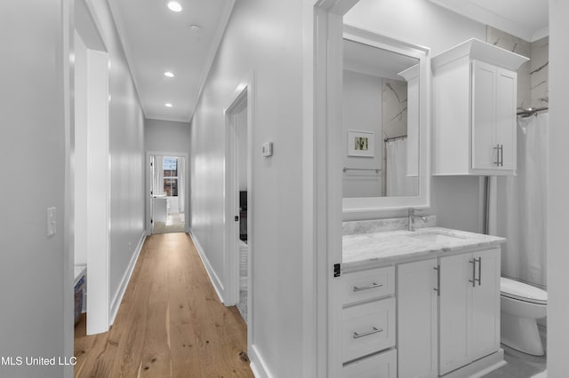 bathroom with hardwood / wood-style floors, vanity, crown molding, toilet, and curtained shower