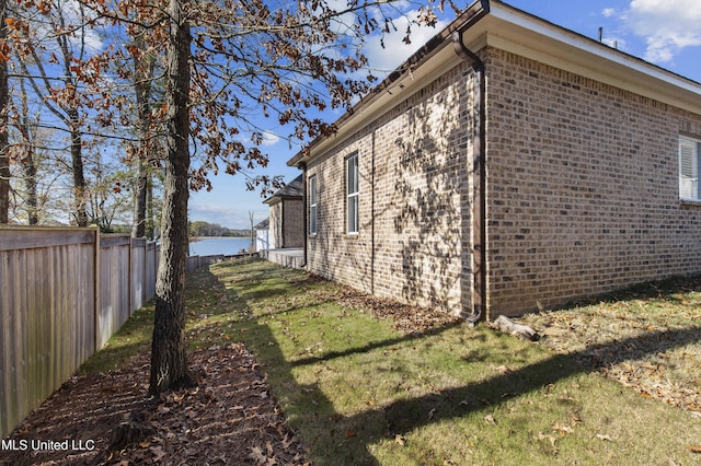 view of side of property with a yard and a water view