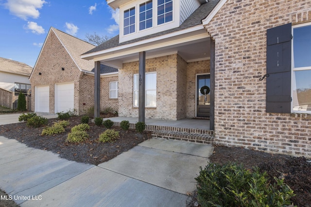 view of exterior entry with a porch and a garage