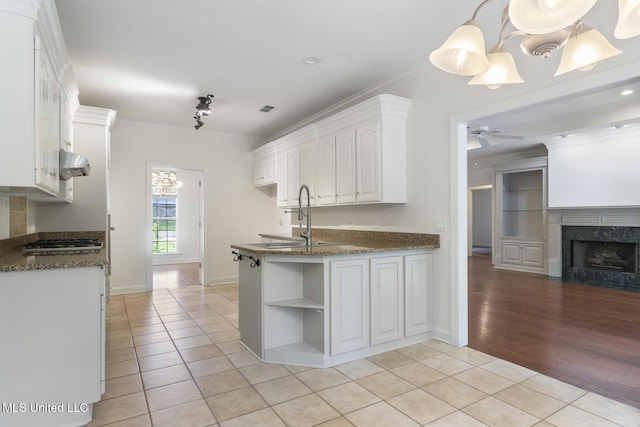 52 Eastgate Dr, Brandon, MS 39042 - kitchen with ventilation hood, ornamental molding, light tile patterned flooring, open shelves, and stainless steel gas stovetop