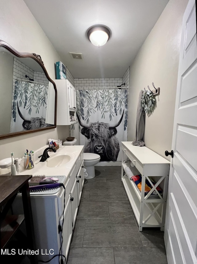 full bathroom featuring visible vents, a shower with shower curtain, toilet, and vanity
