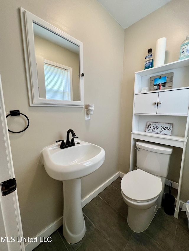 bathroom featuring tile patterned floors, toilet, and baseboards