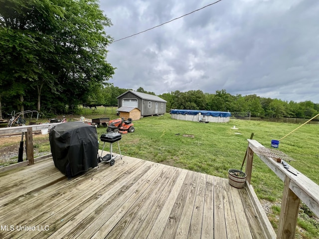 deck with a covered pool, area for grilling, and a lawn