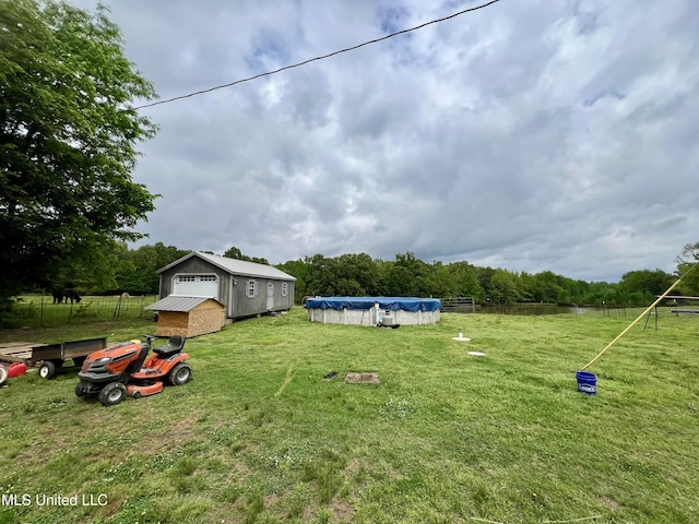 view of yard with fence and a covered pool