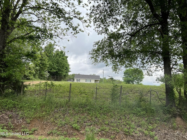 view of yard featuring fence and a rural view
