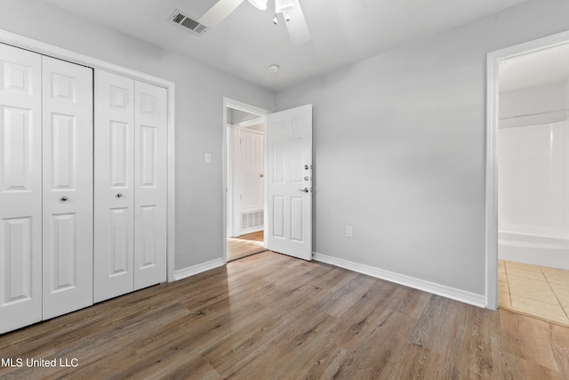 unfurnished bedroom featuring a closet, hardwood / wood-style flooring, and ceiling fan