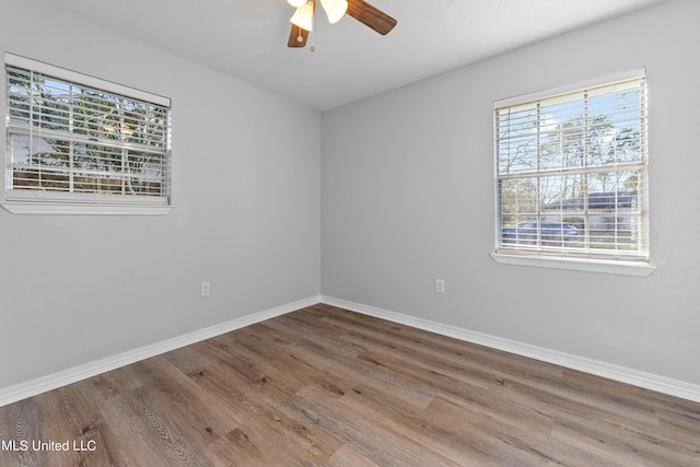 empty room with hardwood / wood-style floors, ceiling fan, and a wealth of natural light