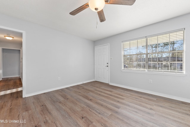 empty room featuring light wood-type flooring and ceiling fan