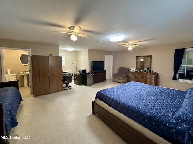 bedroom featuring sink, ceiling fan, and connected bathroom