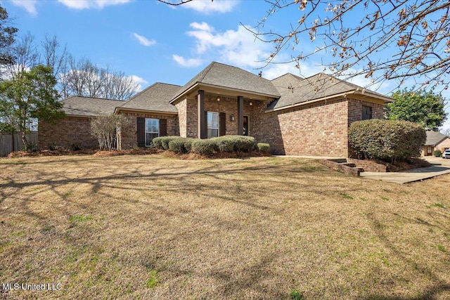 single story home with brick siding, a front lawn, and fence