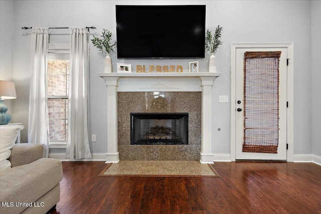 unfurnished living room with wood finished floors, a fireplace, and baseboards