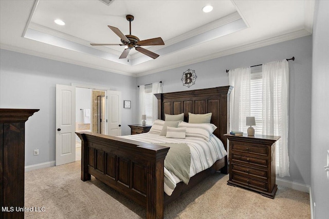 bedroom with a tray ceiling, crown molding, light colored carpet, and baseboards