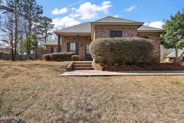 view of front facade with brick siding and a front yard