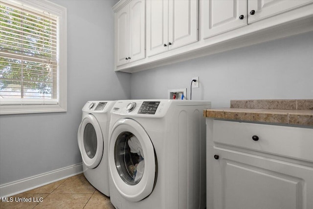 laundry area with cabinet space, washer and dryer, baseboards, and light tile patterned flooring