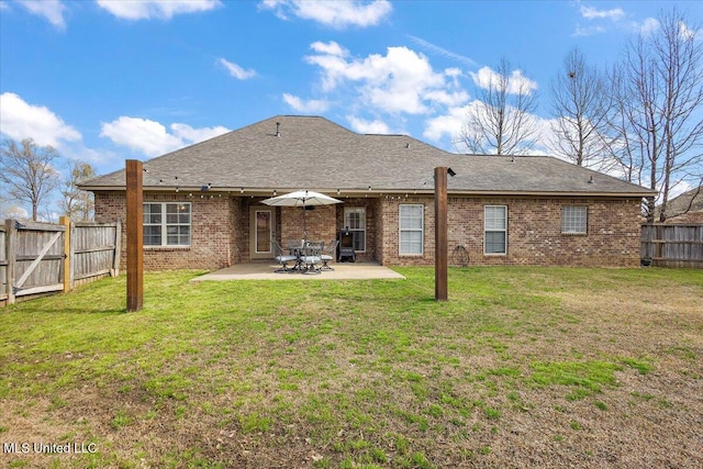 back of property featuring a patio, brick siding, a fenced backyard, and a lawn