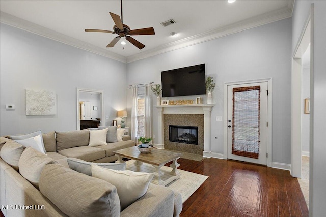 living room featuring visible vents, wood-type flooring, a fireplace with flush hearth, and ornamental molding