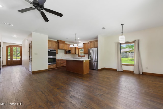kitchen with appliances with stainless steel finishes, light countertops, dark wood finished floors, baseboards, and recessed lighting
