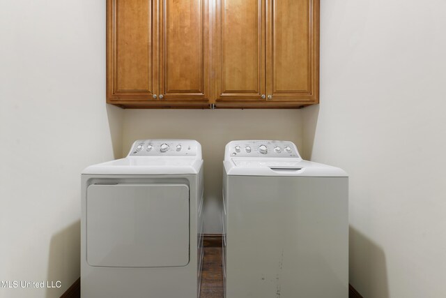laundry area featuring cabinet space, washing machine and dryer, and wood finished floors