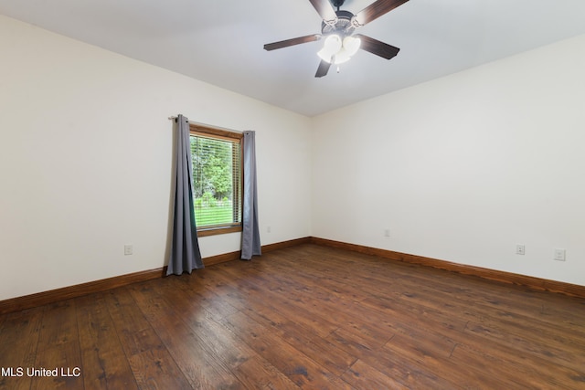 spare room with dark wood finished floors, baseboards, and a ceiling fan