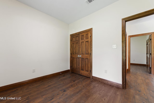 unfurnished bedroom featuring dark wood finished floors and baseboards