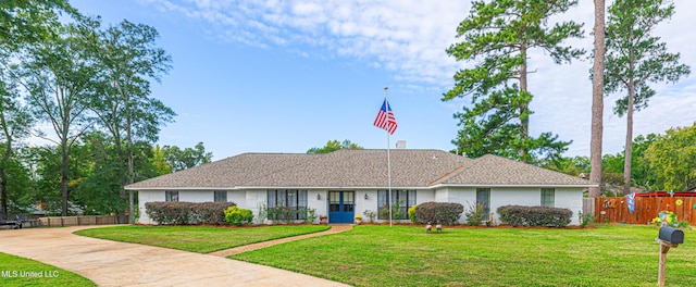 ranch-style house with a front lawn, fence, and brick siding