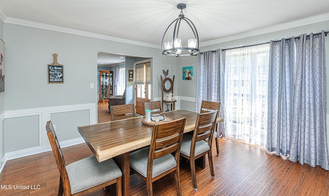 dining area featuring a chandelier, crown molding, and wood finished floors